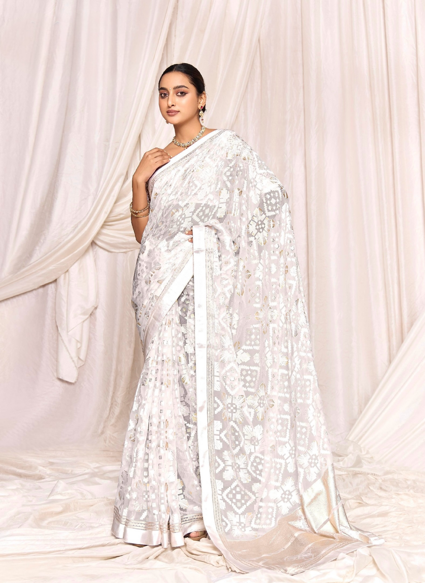 Pure Brasso fabric with Exclusive Off-White colored Designed with Featuring Interactive Silver Foil Touch with Rich Traditional Border Ideal for Day to Evening Events.