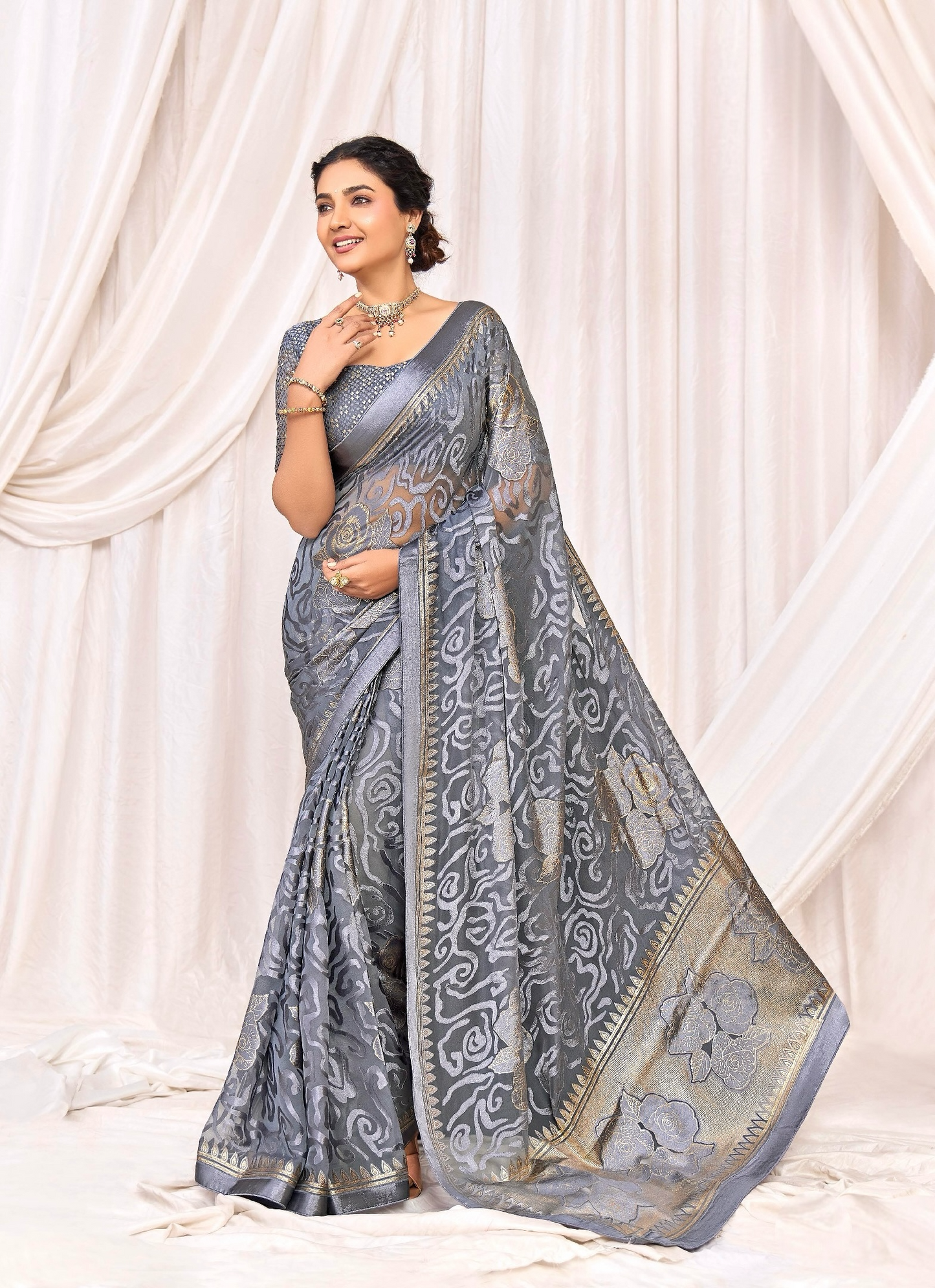 Pure Brasso fabric with Exclusive Metallic Grey colored Designed with Featuring Interactive Gold & Silver Foil Touch with Rich Traditional Border Ideal for Day to Evening Events.